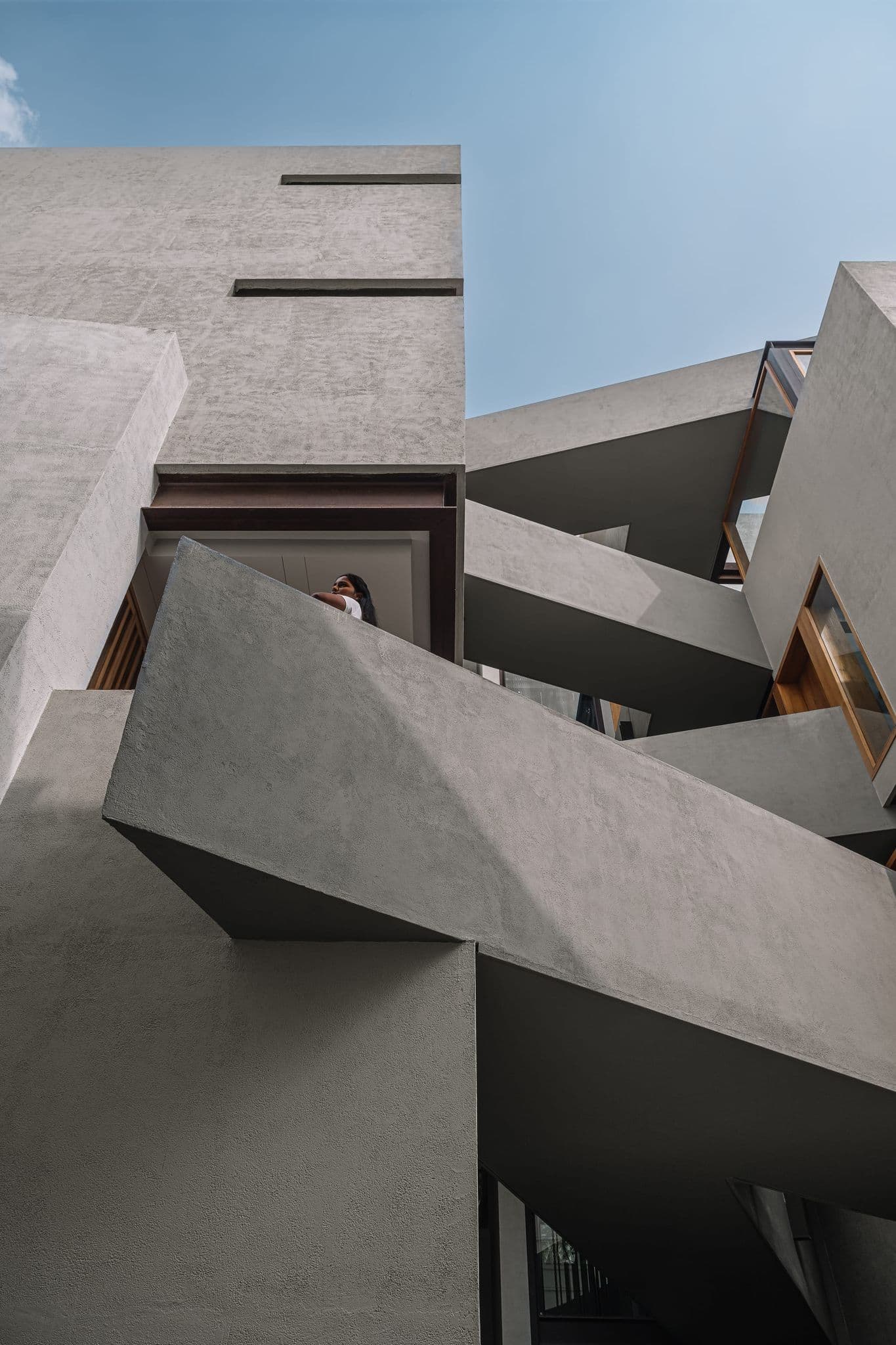 Low-angle view of Hira's cantilevered concrete forms against an open sky
