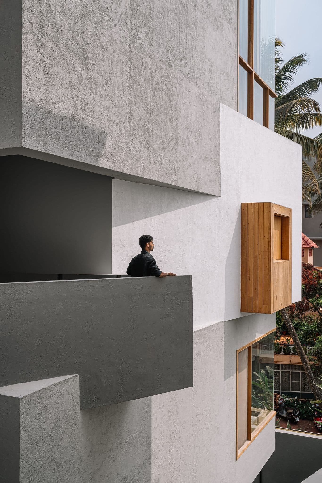 Stacked Hira balconies — concrete planes, timber openings, and human scale