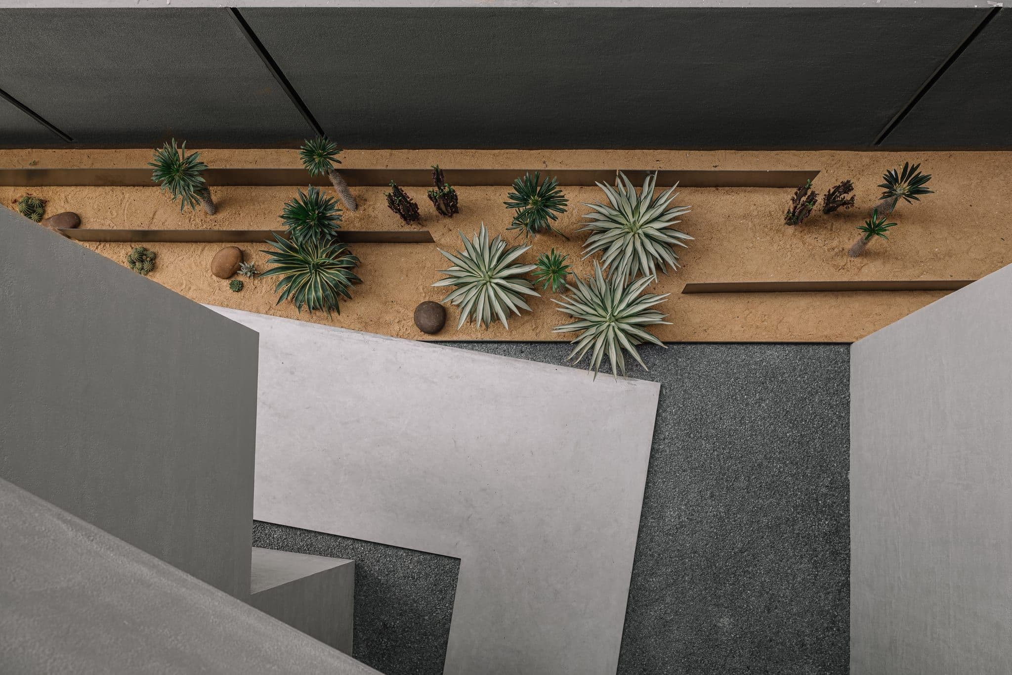 Hira concrete geometry at human scale — raw material and precise shadow
