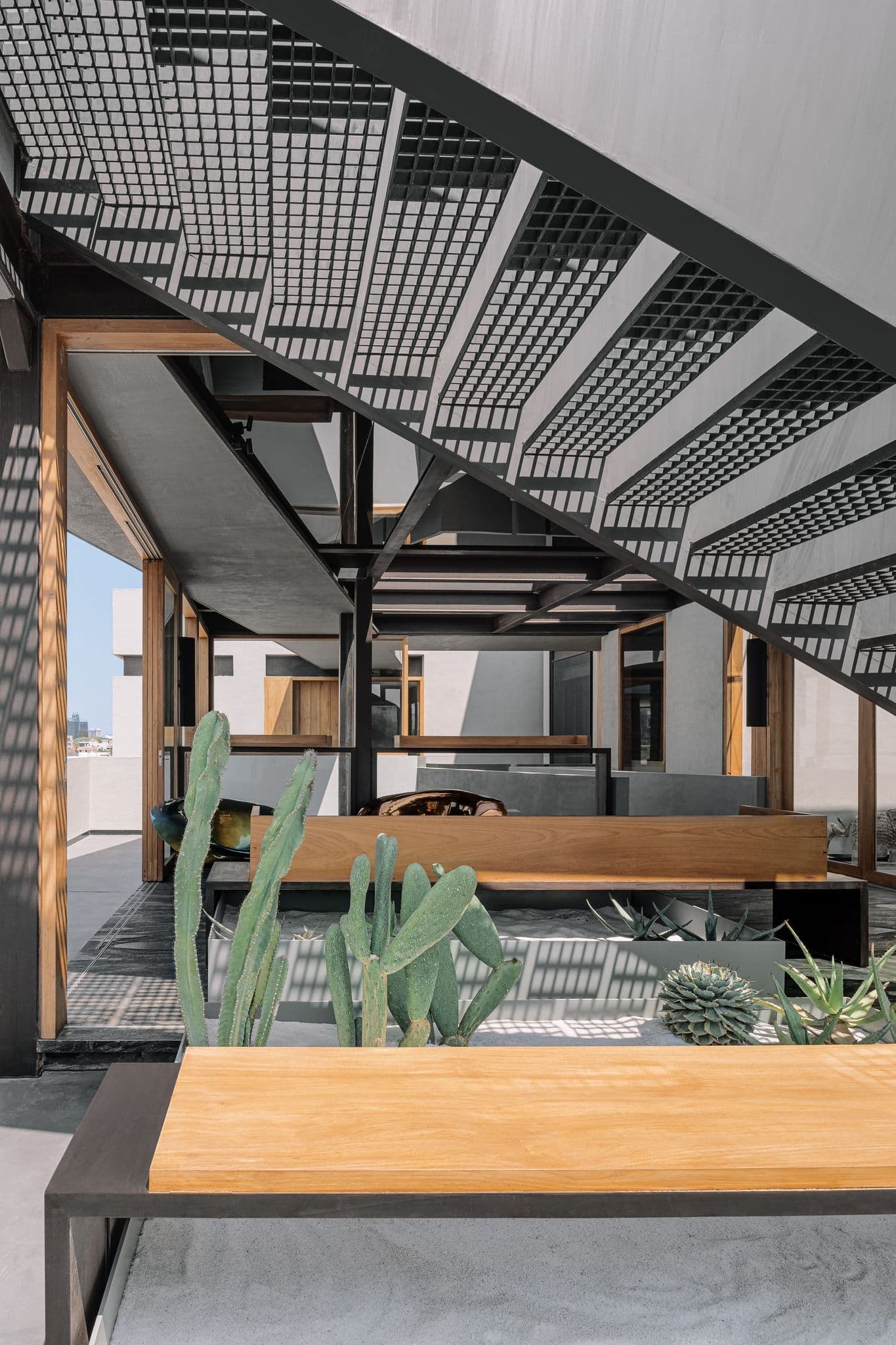 Event-friendly studio zone with grid stair, timber table, and flexible seating.